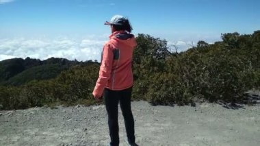 genç erkek ellerini kaldırdı bir dağın tepesinde duran dağ alanının üst ulaşan