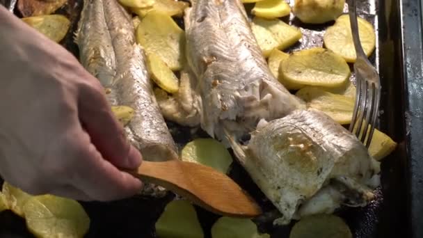 Взяв кусок рыбы из только что приготовленного домашнего блюда, рыбы и чипсов — стоковое видео