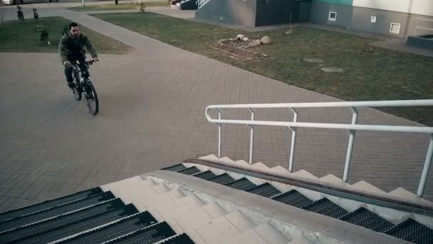 Ember csinál trükköt kerékpárral, lovagolni belül a bejárat — Stock videók