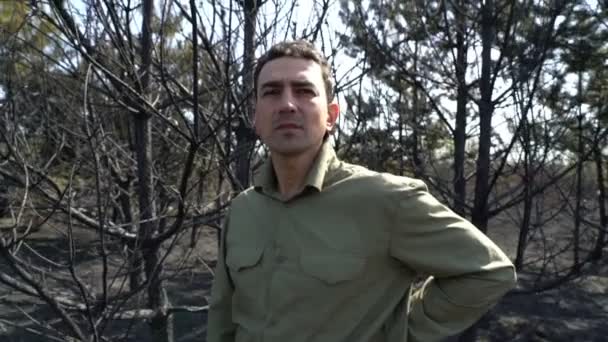 Hombre desesperado parado en un bosque quemado por un incendio forestal, catástrofe ecológica — Vídeos de Stock