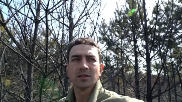 Hombre desesperado parado en un bosque quemado por un incendio forestal, catástrofe ecológica — Vídeos de Stock