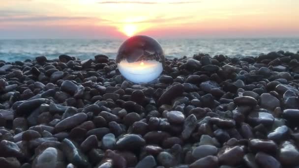 Beutifull zonsondergang reflectie binnen kristallen bol op stenen, zon over water, strand, landschap — Stockvideo