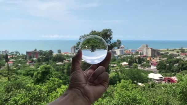 Рука держит волшебный кристалл мяч над красивой природой ландшафт, концепция путешествия — стоковое видео