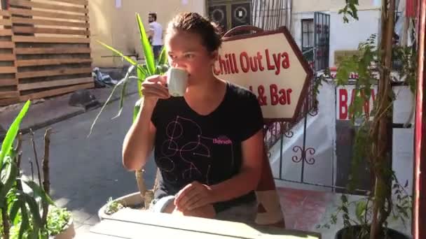 Woman relaxing outside on Istanbul street holding cup , drinking coffee or tea on morning sunshine — Stock Video