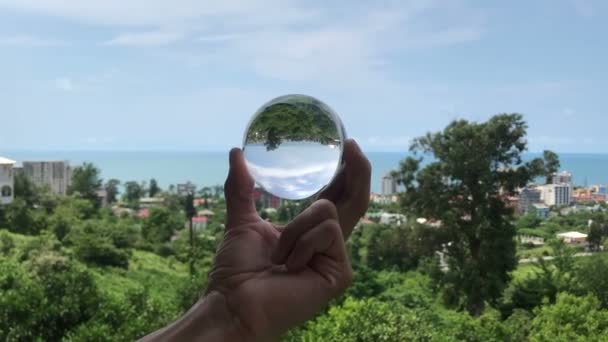 Mão segurando bola cristalina mágica sobre bela paisagem natureza, conceito de viagem — Vídeo de Stock