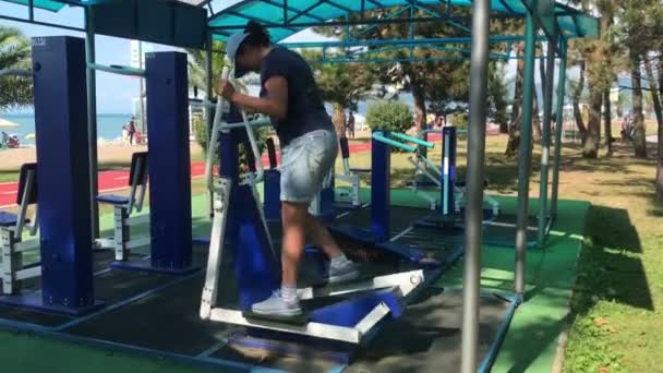 Kobieta z nadwagą robi cardio ćwiczenia na elipsoidy na siłowni na zewnątrz w parku — Wideo stockowe