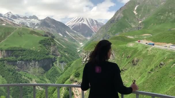Vrouw staand op uitkijkpunt en bewonder bergen landschap — Stockvideo