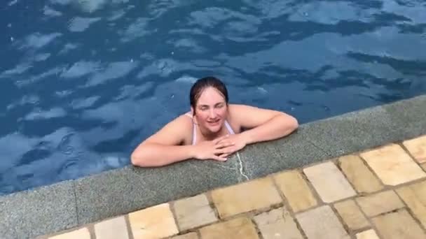 Frau schwimmt im Pool, entspannend, glücklich, Urlaubszeit — Stockvideo