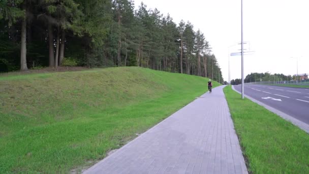 Nő kerékpáros, női lovaglás kerékpár az utcán, gyorshajtás hegy nélkül sisak, veszélyes lovaglás — Stock videók