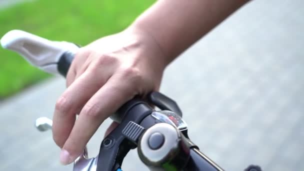 Frenado de bicicleta, mano femenina usando campana de bicicleta y freno para parada repentina — Vídeos de Stock