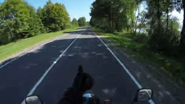 Motocyklista jezdí na krásné krajině malebná a prázdná lesní cesta v Bělorusku a ukazuje palce — Stock video
