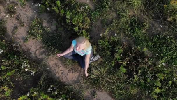 Aerial view Beautiful and healthy female breathing gently and sits in pose of lotus or sukhasna — Stock Video