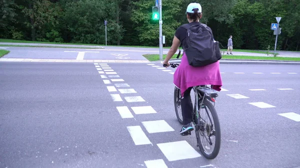 Женщина-велосипедистка, женщина-велосипедистка на перекрестке улицы без шлема, пешеходный велосипед, велосипед Стоковая Картинка