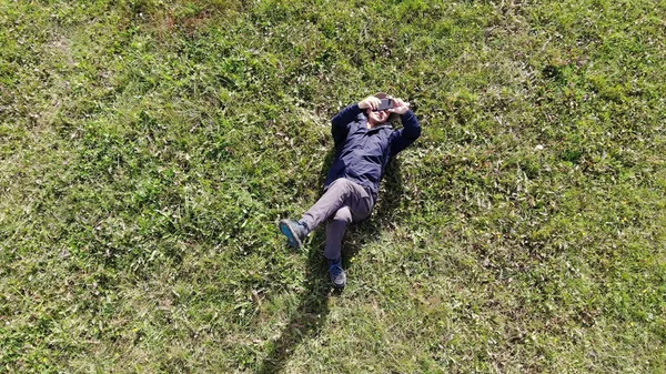 Muž, který ležel na trávě a dělal ze vzduchu výstřelu — Stock fotografie