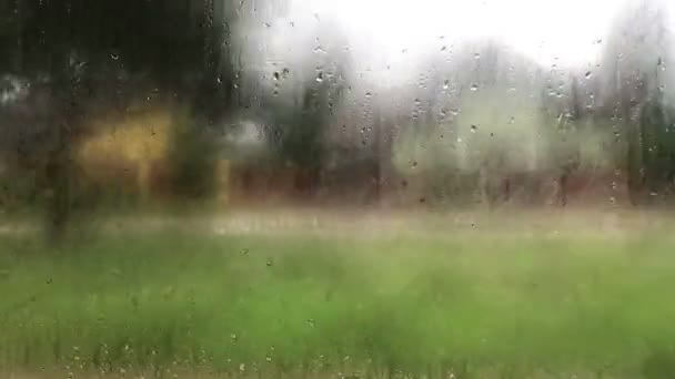 Regenachtige dagen, regendruppels op het raamoppervlak die de stad uitreizen — Stockvideo