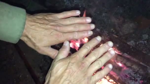 L'homme néandertalien se réchauffe les mains par le premier feu de joie dans sa grotte 