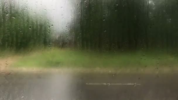 Yağmurlu günler, şehir dışına seyahat pencere yüzeyinde yağmur damlaları — Stok video
