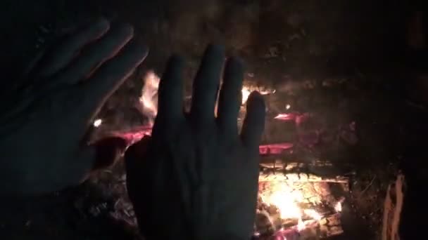 Неандертальця людини гріє руки біля першого багаття в його печері — стокове відео