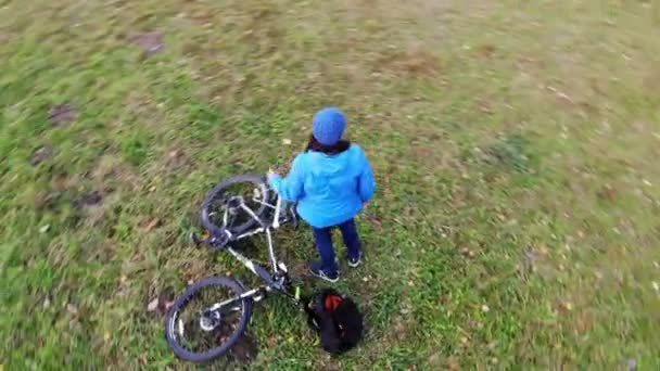 Mulher ciclista relaxante ter descanso no gramado verde, tiro aéreo, esporte estilo de vida feliz — Vídeo de Stock