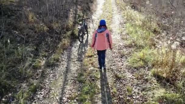 Kerékpáros nő biciklizés a vidéki úton autun erdőben, szórakozás és élvezi az életet — Stock videók