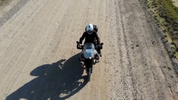 Езда на большом мотоцикле по проселочной дороге, воздушный кадр — стоковое видео