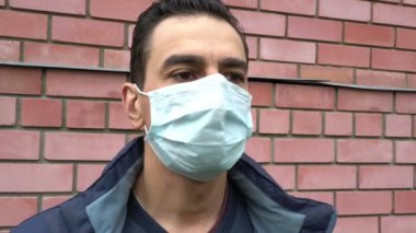 Tıbbi maskeli adam nefes nefese, boğuluyor, boğuluyor, hasta, ağır öksürüyor, nefes nefese kalıyor, acı çekiyor.