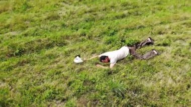 Adam yere düştü, yeşil çimenlere uzandı baygın, kötü hissediyordu, nefes nefese, gaz maskesi yakınındaydı.