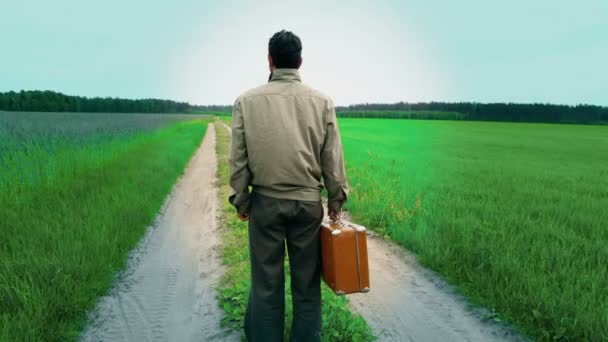 Hombre solitario confundido, en duda, de pie junto al camino del campo, camino de la vida, la celebración de la maleta, decisión — Vídeos de Stock