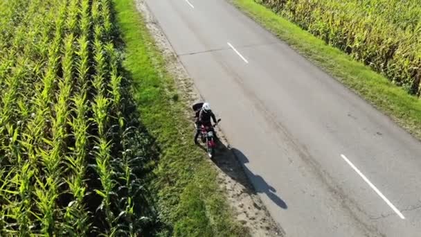 Motorradfahren auf der Landstraße bei Sonnenuntergang, schöne Abenteuerreiseaufnahmen von der Drohne, oben — Stockvideo