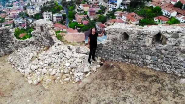 Mujer viajero investigando viejas ruinas en castillo antiguo, descubrir la historia, tiro aéreo de dron — Vídeo de stock