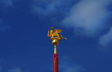 Mavi gökyüzü, eski Venedik Cumhuriyeti savaş sembolü karşı bir kılıç wielding Saint Mark kanatlı aslan altın heykelciği
