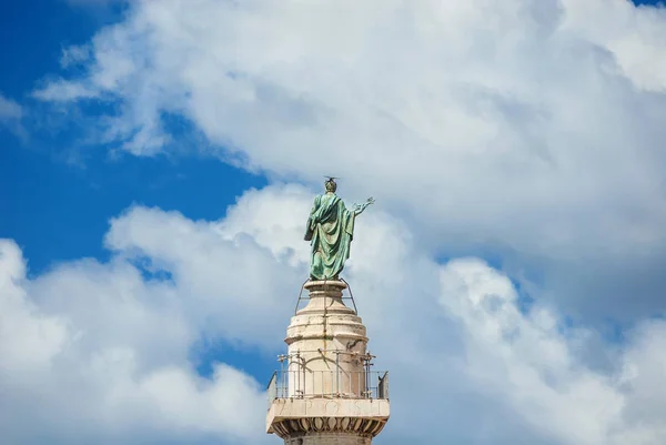 St Peter Apostle bronze statue with Bible and Keys of Heaven at the top of Trajan Column with clouds, in the historic center of Rome (16th century)