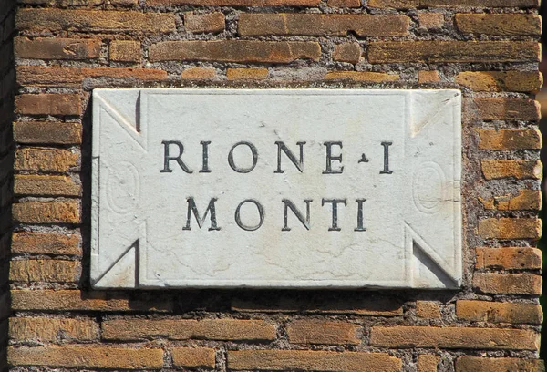 Bir tuğla duvara 'Rione Monti', ilk ve en eski bölgesi Roma'nın tarihi merkezinde, eski mermer levha yol olarak imzala