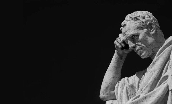 Man statue in the act of thinking against blue sky. Ancient Roman Julian the Jurist statue made at the end of 19th century in front of the Old Palace of Justice in Rome (Black and White with copy space)