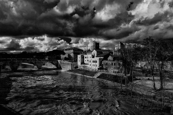 ローマの冬 黒と白の下ティベリーナ島堤防に沿って川が腫れています — ストック写真