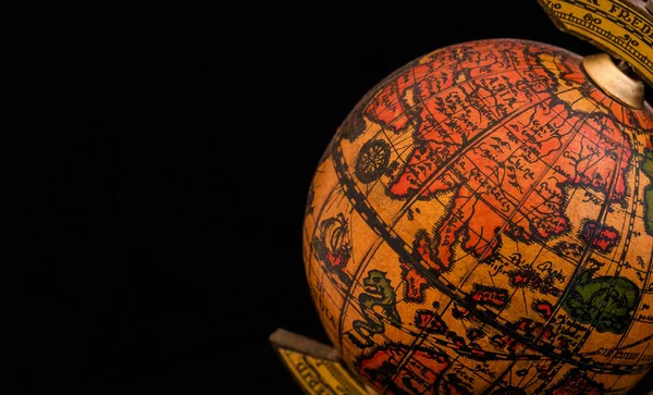 Ancient globe replica with map of East Asia countries on Eastern Hemisphere during the Age of Discovery (on black background with copy space)