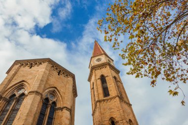 Sonbahar ve kış aylarında Arezzo. Gotik katedral apsis ve ikonik çan kulesi sarı yapraklar ve bulutlu gökyüzü görünümü