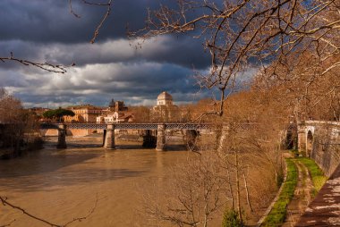 Kışın güneşli ve bulutlu gün boyunca Tiber Nehri'nin, Roma görüntülemek çıplak dal ağaçların arasından