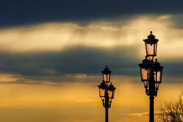 Weneckie lampy z Zachodem nieba — Zdjęcie stockowe