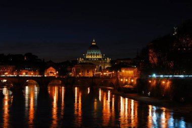 Roma 'da gece. Tiber nehri boyunca romantik bir atmosferde aydınlanan ikonik Aziz Peter manzarası.