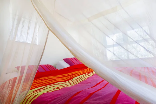 Bed Met Kleurrijke Quilt Onder Een Klamboe — Stockfoto