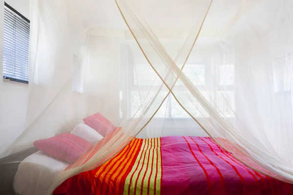 Bed Met Kleurrijke Quilt Onder Een Klamboe — Stockfoto
