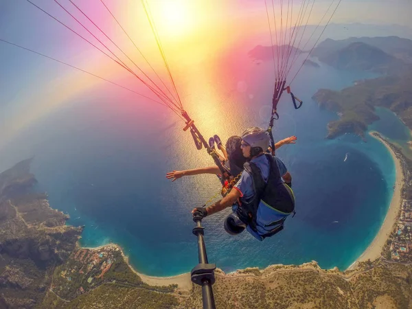 Yamaç paraşütü gökyüzünde. Yamaçparaşütü tandem denizin masmavi bir deniz ve dağ üzerinde parlak güneşli bir günde uçan. Yamaçparaşütü ve Blue Lagoon Ölüdeniz, Türkiye'de hava görünümünü. Aşırı spor. Manzara