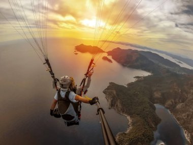 Yamaç paraşütü gökyüzünde. Yamaçparaşütü tandem denizin masmavi bir deniz ve dağ üzerinde parlak güneşli bir günde uçan. Yamaçparaşütü ve Blue Lagoon Ölüdeniz, Türkiye'de hava görünümünü. Aşırı spor. Manzara