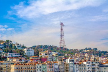 Bir tepede yüksek voltajlı elektrik hatları. İstanbul, Türkiye'de konut lar üzerinde elektrik kulesi 