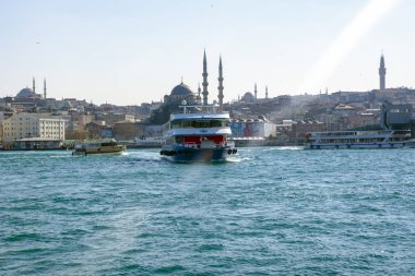 İstanbul, Türkiye 03 Nisan 2019: Türkiye'de Müslüman mimarisi ve su taşımacılığı - İstanbul Boğazı'nda deniz yolculuğundan gelen turistik manzaralar. Gün batımında İstanbul Şehir Manzarası - eski cami ve türk vapurları, Haliç manzarası.