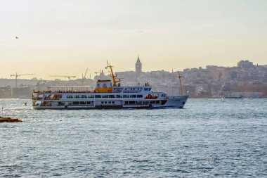 İstanbul, Türkiye 03 Nisan 2019: Türkiye'de Müslüman mimarisi ve su taşımacılığı - İstanbul Boğazı'nda deniz yolculuğundan gelen turistik manzaralar. Gün batımında İstanbul Şehir Manzarası - eski cami ve türk vapurları, Haliç manzarası.