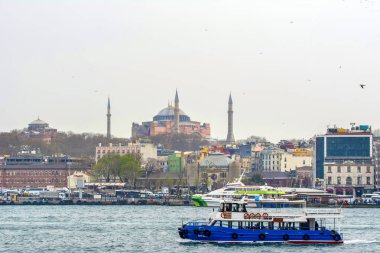 İstanbul, Türkiye 03 Nisan 2019: Türkiye'de Müslüman mimarisi ve su taşımacılığı - İstanbul Boğazı'nda deniz yolculuğundan gelen turistik manzaralar. Gün batımında İstanbul Şehir Manzarası - eski cami ve türk vapurları, Haliç manzarası.