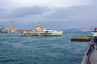 İstanbul, Türkiye 03 Nisan 2019: Türkiye'de Müslüman mimarisi ve su taşımacılığı - İstanbul Boğazı'nda deniz yolculuğundan gelen turistik manzaralar. Gün batımında İstanbul Şehir Manzarası - eski cami ve türk vapurları, Haliç manzarası.