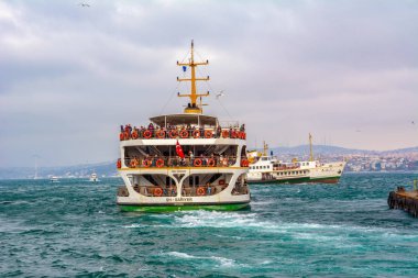 İstanbul, Türkiye 03 Nisan 2019: Türkiye'de Müslüman mimarisi ve su taşımacılığı - İstanbul Boğazı'nda deniz yolculuğundan gelen turistik manzaralar. Gün batımında İstanbul Şehir Manzarası - eski cami ve türk vapurları, Haliç manzarası.
